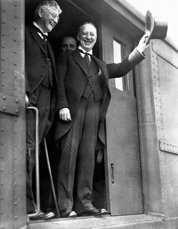 United States presidential candidate Alfred E. Smith (r) raises his hat in salute during a train trip to promote his bid for the 1928 presidency. 