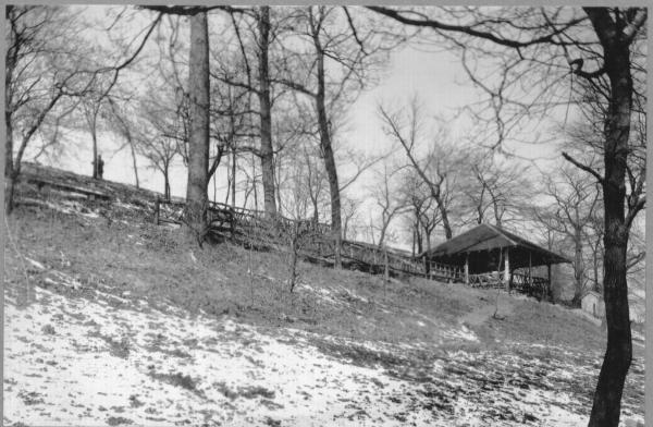 Winter image of fence and pavilion on a hillside constructed by the CCC