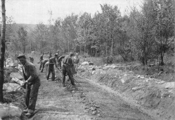 Black and white photo of CCC workers hand grading road   