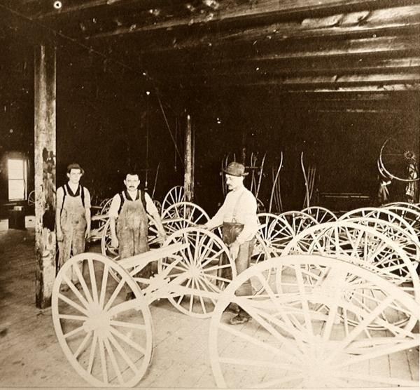 Carriage Works paint shop interior with workers and carriages.