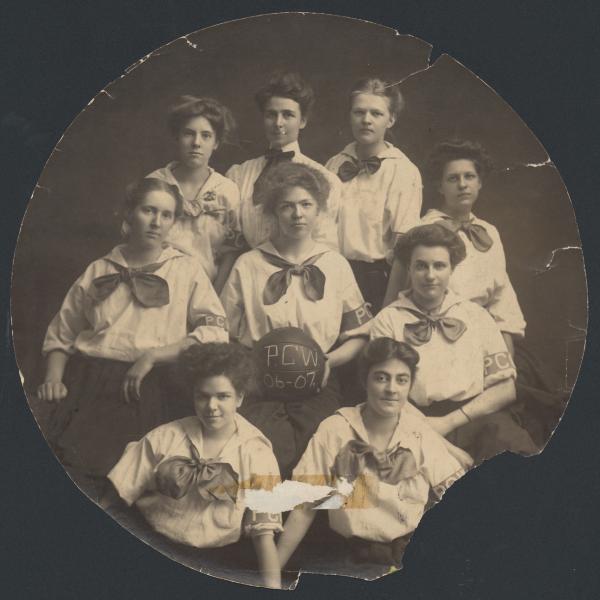 Nine members of the Basketball team pose with inscribed play ball. The uniforms include a PCW arm band.
