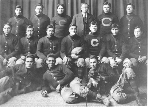 Jim Thorpe and 1911 Carlisle Indian School Football Team with football which reads "1911, Indians 18, Harvard 15) 