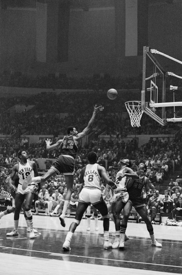 Wilt Chamberlain Shooting for the Basket, other players are on the court, game in progress.