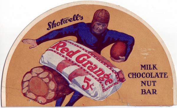 A football player in a blue uniform carries a football and appears to be running. A photograph of two candy bars, one in a red, white, and blue wrapper, and the other unwrapped are in the center of the advertisement. The wrapped bar  label reads Red Grange, 5¢