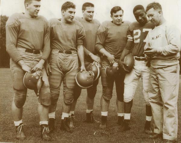 Willie Thrower with his Michigan State teammates, in uniform, and Coach Biggie Mann. 