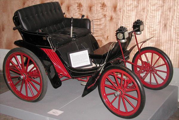Color photograph of a black Duryea with read trim and red spokes.