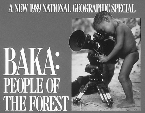 A young, native child looks through the lens of a television camera.