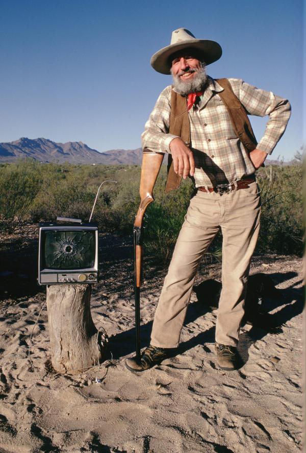 Edward Abbey with his shotgun and freshly bagged television complete with a bullet hole through the screen. 