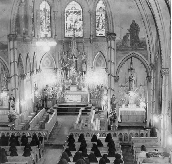 The interior of the ornate college chapel, with nuns at prayer during the school day.