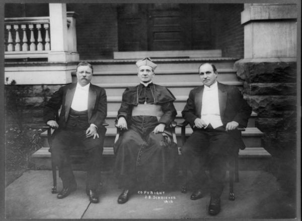 Theodore Roosevelt, Rev. M.J. Hoben, and John Mitchell, posed, seated in front of porch