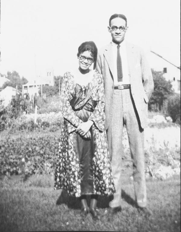 A man and young woman standing outdoors pose for photo.