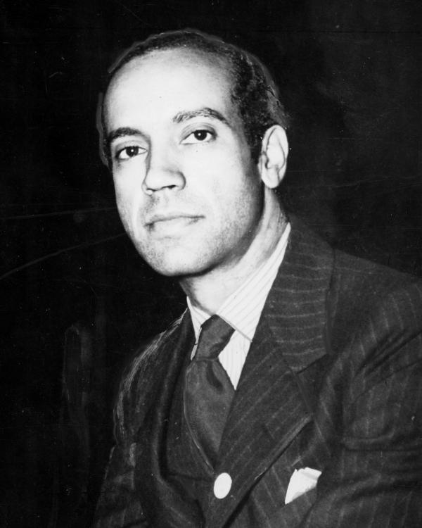 Head and shoulders photograph of a man wearing a suit jacket and tie.