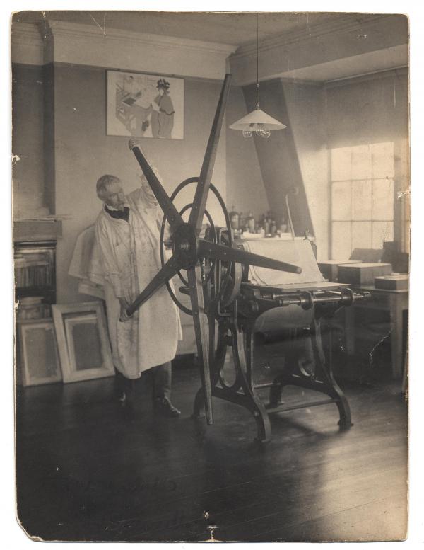Pennell in his studio with printing press. 