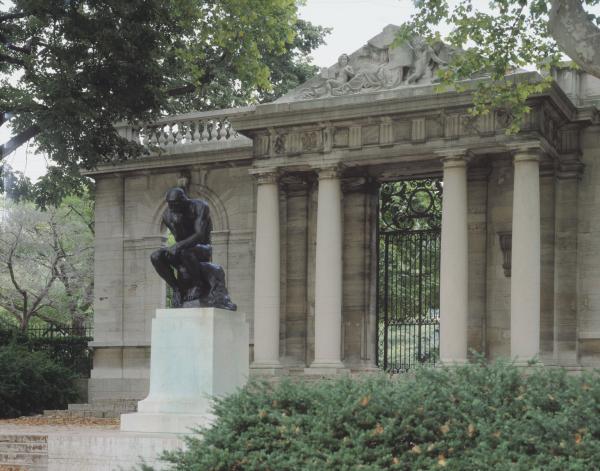 Color image of the front of the Rodin Museum building, with the sculpture of the "Thinker" in the foreground