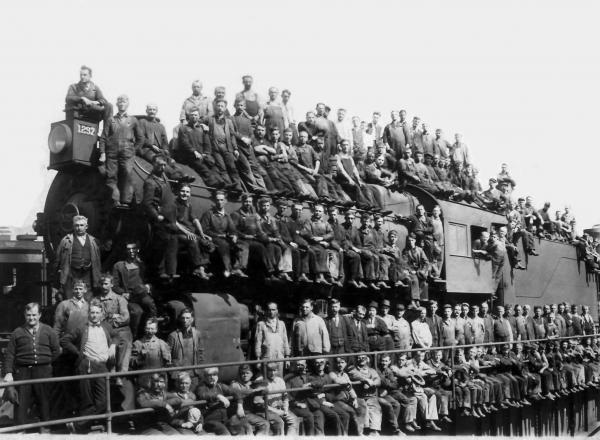 Image of dozens of men atop a locomotive   