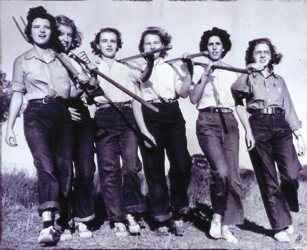 Image of women carrying farming tools.