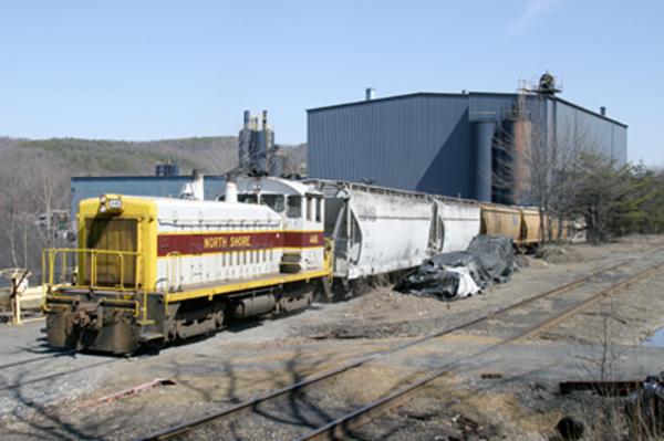 The Shamokin Valley RR sunny-day view with the dark-colored industry building in the background. 