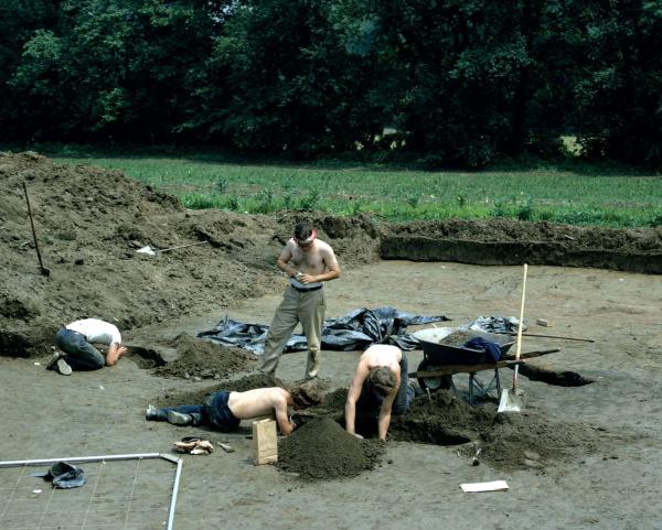 In this photograph crew members investigate refuse-filled pits. 