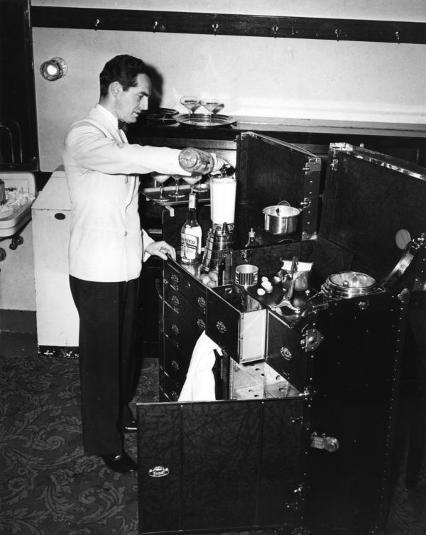 Waring standing, with his blender invention on top of his travel trunk.  
