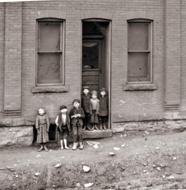 A group of immigrant children stand in a doorway in Johnstown.