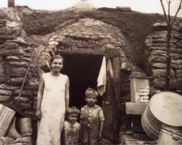 Family standing outside the entrance of their coke oven home 