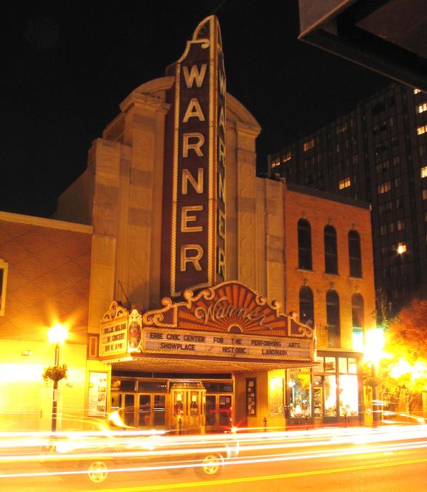 Evening view of the exterior of the theater in lights.