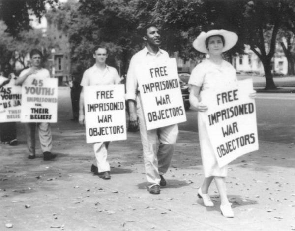 Bayard Rustin, with other marchers, wearing a sign that reads Free Imprisoned War Objectors