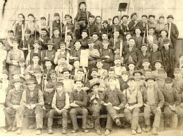 Pottstown Ironworker crew, c. 1861, consisting of Nailers, Heaters, Feeders and Forgers. Notice the tools that the workers hold and the row of children in the top rows.