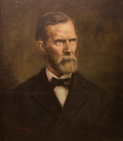 Oil on canvas portrait, head and shoulders, facing front, of a bearded, mustached, man wearing a suit coat, white shirt, and a bow tie.
