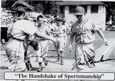 Black and white baseball card of a runner coming into home while the catcher offers his outstretched hand to congratulate the runner.