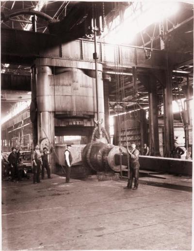 Gelatin printing out paper print, mounted on board of workers processing a 90-ton ingot using a 10,000-ton forging press at Carnegie Steel Company's Homestead Steel Works.