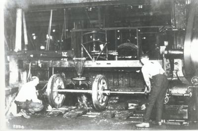 Interior image of workers mounting wheels to axles.