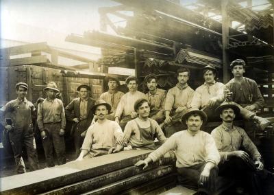 Yard laborers pose next to steel product at the American Sheet and Tin Plate Company, Vandergrift, 1913.