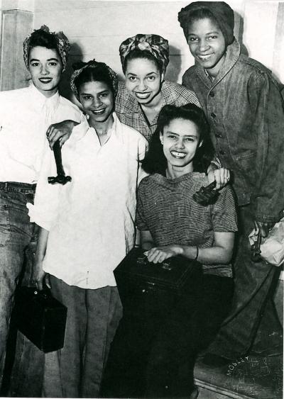 Five women workers pose for a photograph.