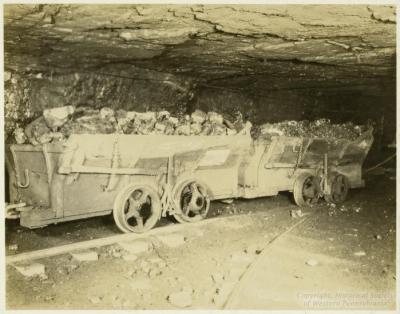Photograph shows loaded coal cars in the mine.