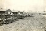 Photograph of the outdoor bunks in rows along the barracks buildings.