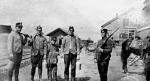 Three adult miners and one young lad pose for a picture with a policeman.