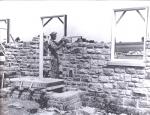 A man lays brick to construct the wall of a house.