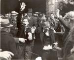 Hershey Chocolate; sit-down strike; workers leaving factory, April 7, 1937.  John Loy, a worker, has a bloody nose. There is also a man with his hand raised holding a weapon.  
