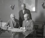 Secretary of the Treasury Andrew Mellon pictured with Assistant Secretary Henry Herrick Bond (seated) are shown the new bills by Director Hall of the Bureau of Engraving and Printing.