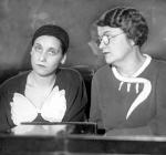Black and white photograph of two women seated at a desk. 