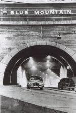 One car exits as another enters a lighted tunnel.