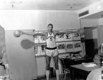 Wilt Chamberlain in uniform, palming two basketballs.