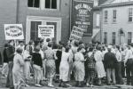 Women walk the picket lines in front of the factory carrying signs that read: Fight for the living wage, Beware Bosses speeches, and Reading Labor Supports Wide Awake Strikers. 