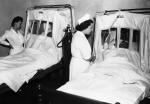 Nurses Betty Tropak (L) and Eleanor Novak supervise oxygen treatment for two of forty persons hospitalized by fume-laden smoke and fog.
