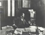 W. E. B. Dubois seated at a desk, in the office of The Crisis