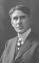 Head and shoulders, wearing a suit and tie, black and white photo.
