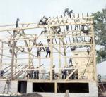 a large group of men building a barn 