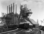 Blast furnaces of the Carnegie Steel Corporation in Pittsburgh, Pennsylvania. Photograph shows an exterior of Steel Plant with smoke stacks and railroad tracks. Undated Photograph.