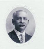 Formal Portrait of a headshot of Dietrick Lamade, sporting a mustache, wearing a suit and tie.